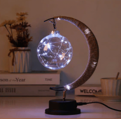 Battery-operated woven hemp crescent moon lamp with a silver bulb – shown lit