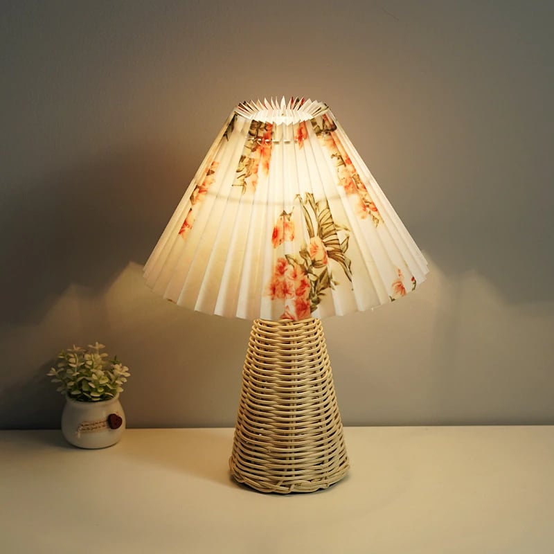Round pleated rattan lamp with a handwoven floral pattern – shown lit