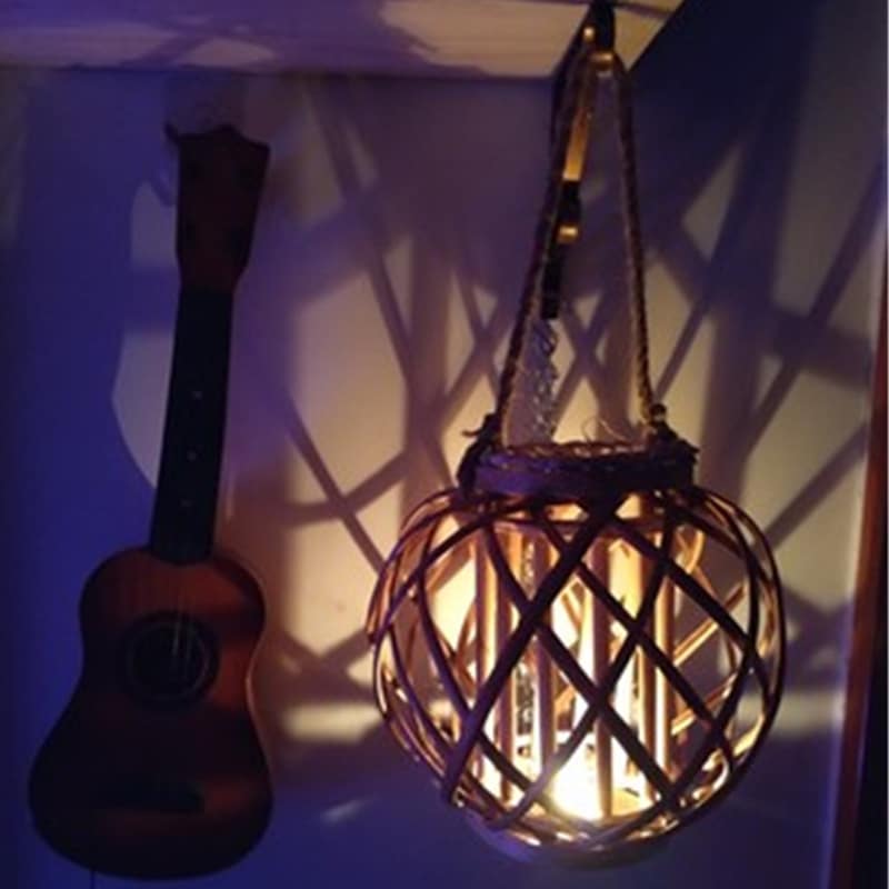Square retro rattan lantern with spiral woven rope – shown lit in a room setting (3)