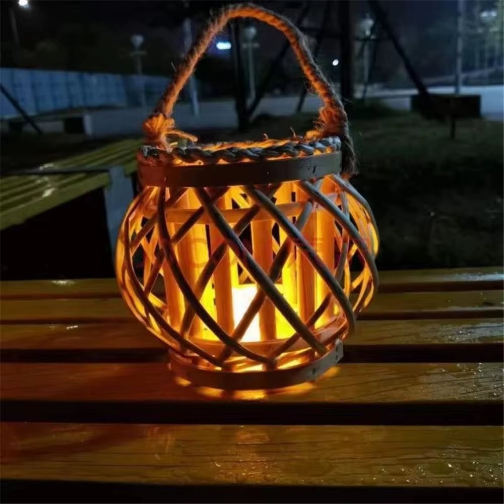 Modern rattan slat lantern with a braided handle – shown lit in a room setting