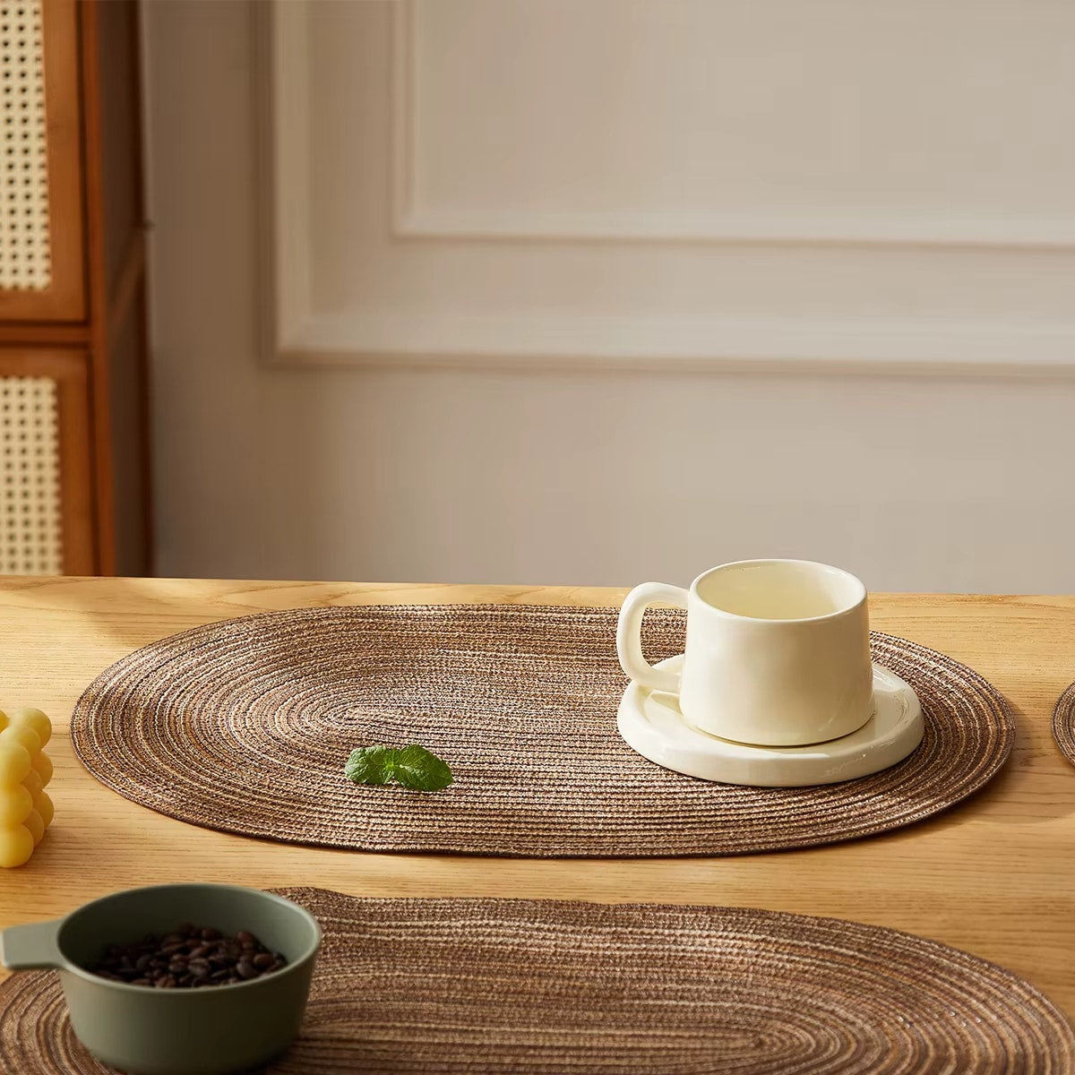 Set of four chic oval straw-look placemats – shown in a room setting (2)