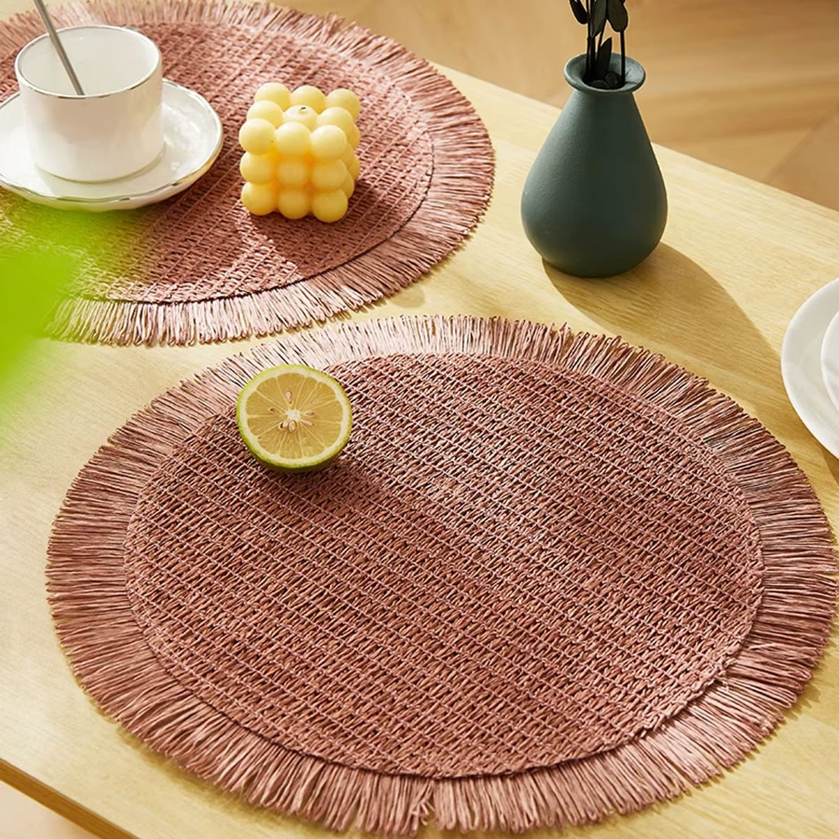 Set of four pastoral straw-look placemats in pink – shown in a room setting