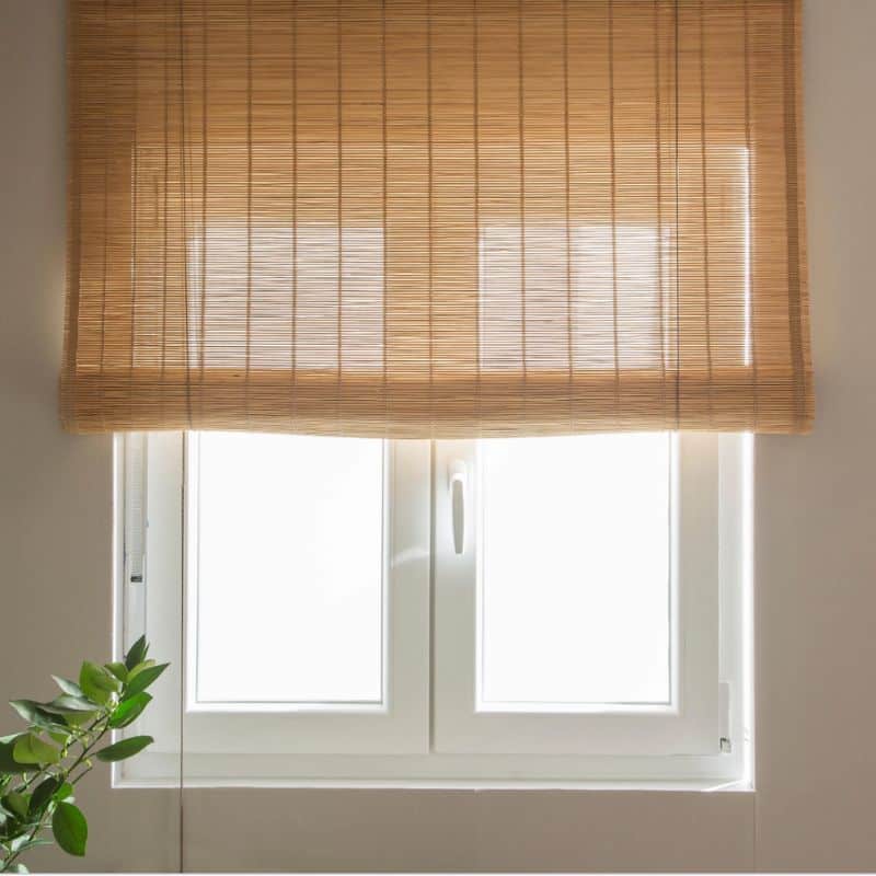 Set of two hand-woven bamboo roll-up blinds – shown in a room setting