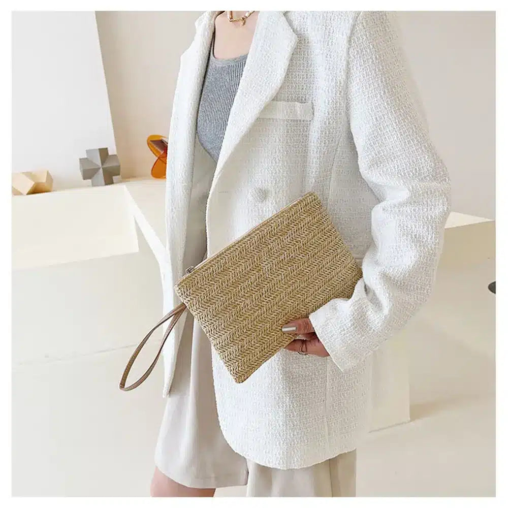 Woven rattan clutch with a brown strap – worn by a model (4)