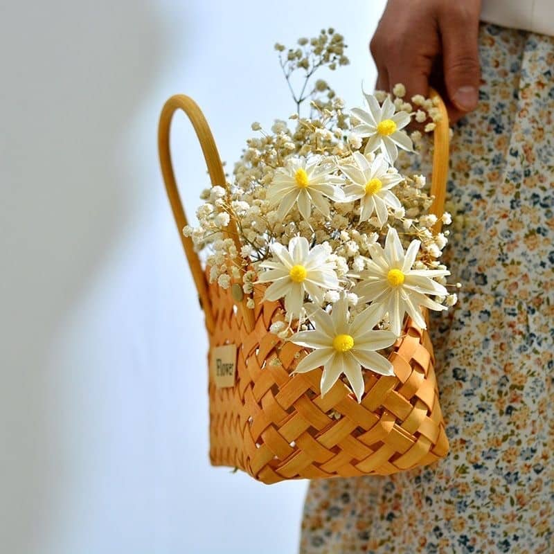 Mini woven flower basket with painted florals and white fabric lining – shown in use