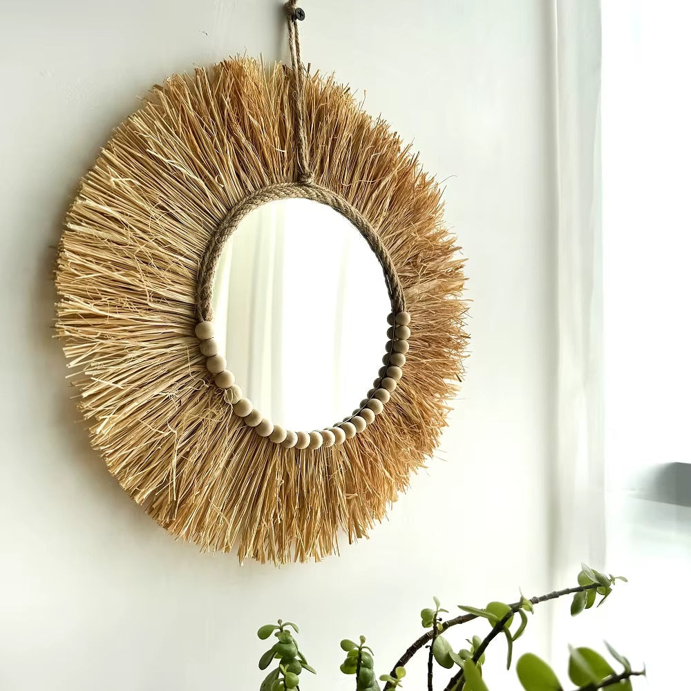 Boho round straw mirror with warm golden highlights – shown in a room setting (2)