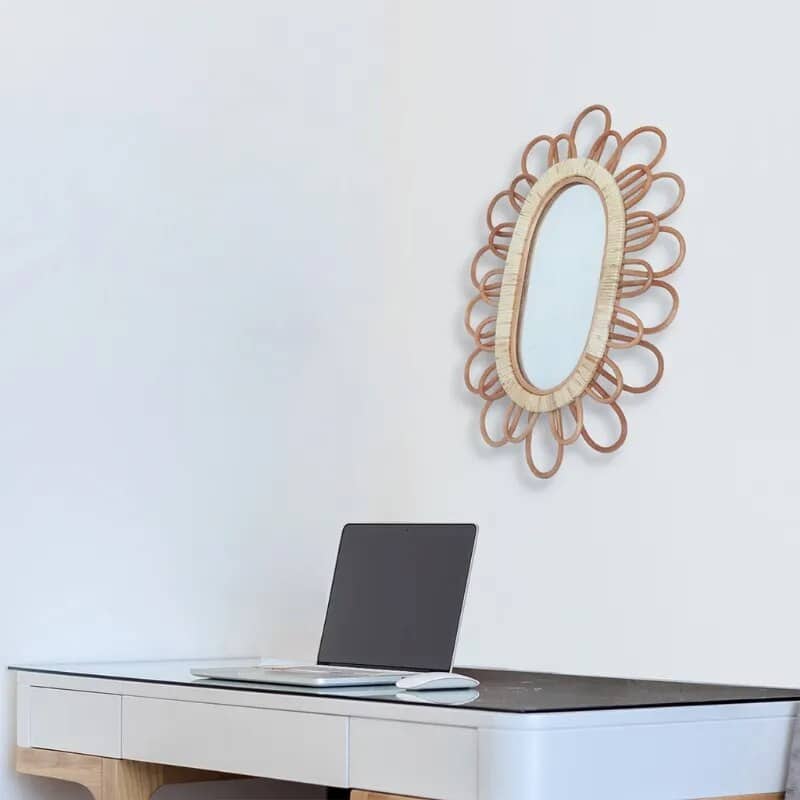 Oval rattan wall mirror with a hand-braided frame – shown in a room setting
