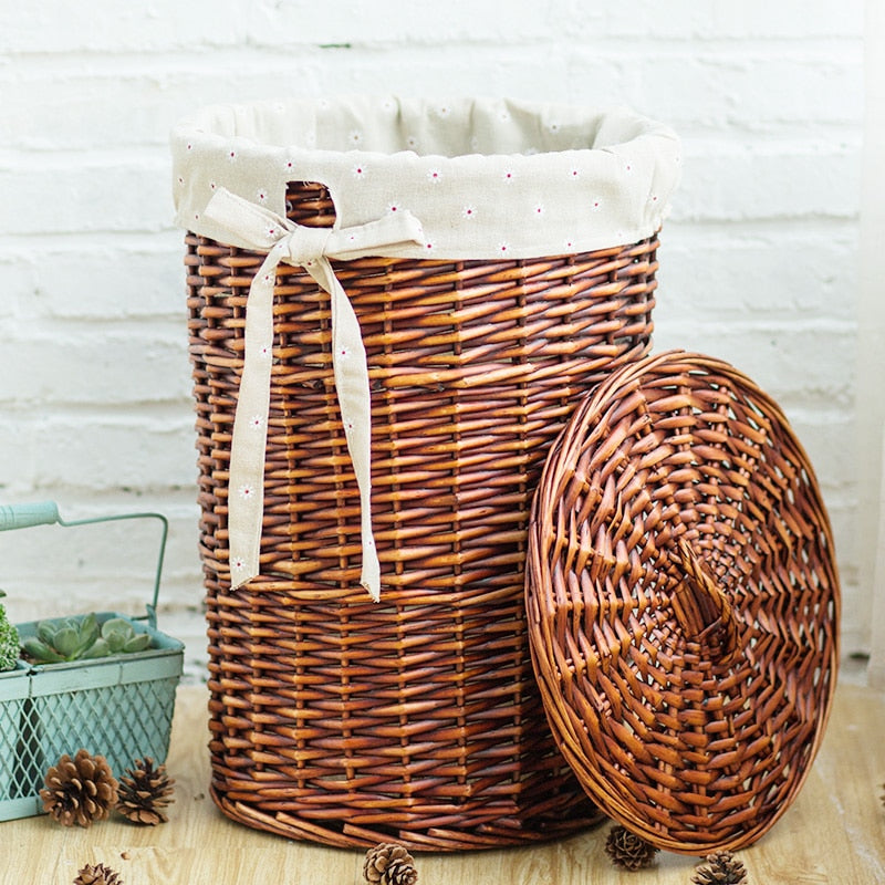 Dark rattan laundry basket with a fitted lid – shown in a room setting