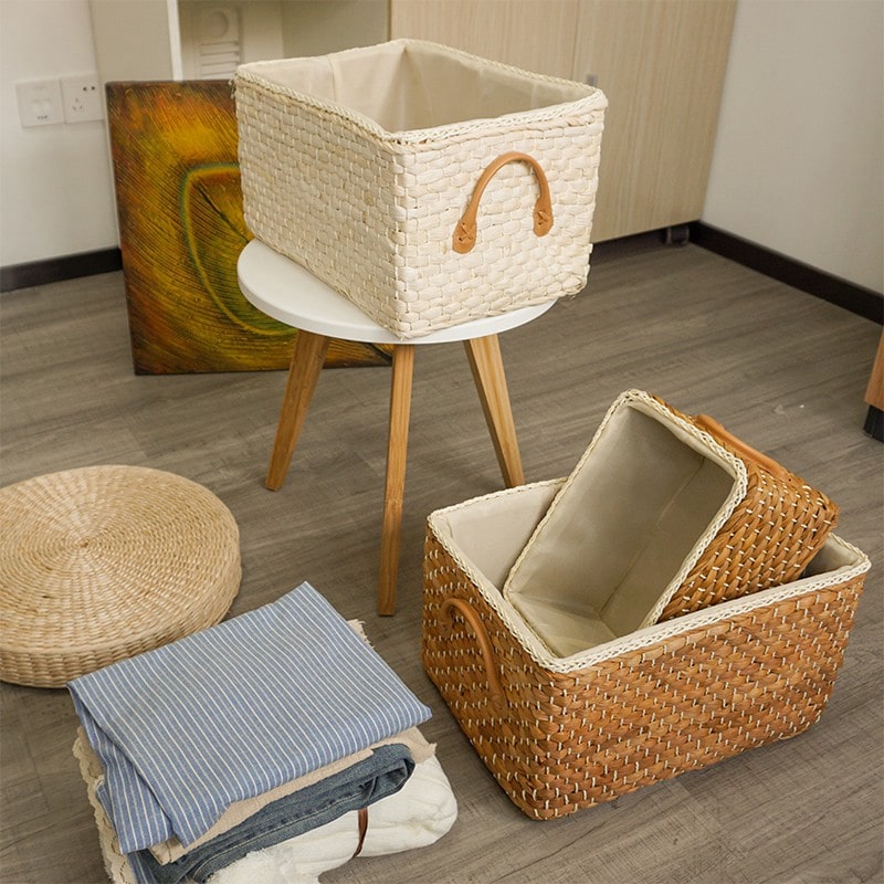 Handwoven wicker storage basket with two handles – shown in a room setting (3)