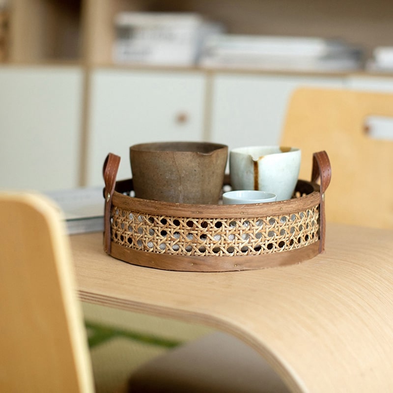 Brown rectangular handwoven rattan storage basket with handles – shown in a room setting