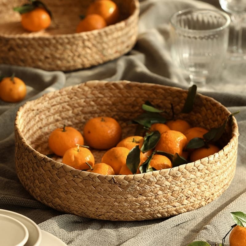 Round handwoven rattan basket with a center handle – shown in a room setting