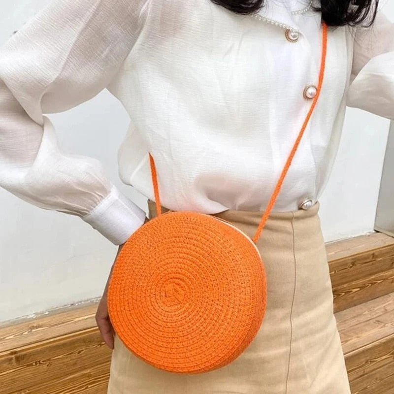 Round orange wicker-look shoulder basket bag – worn by a model