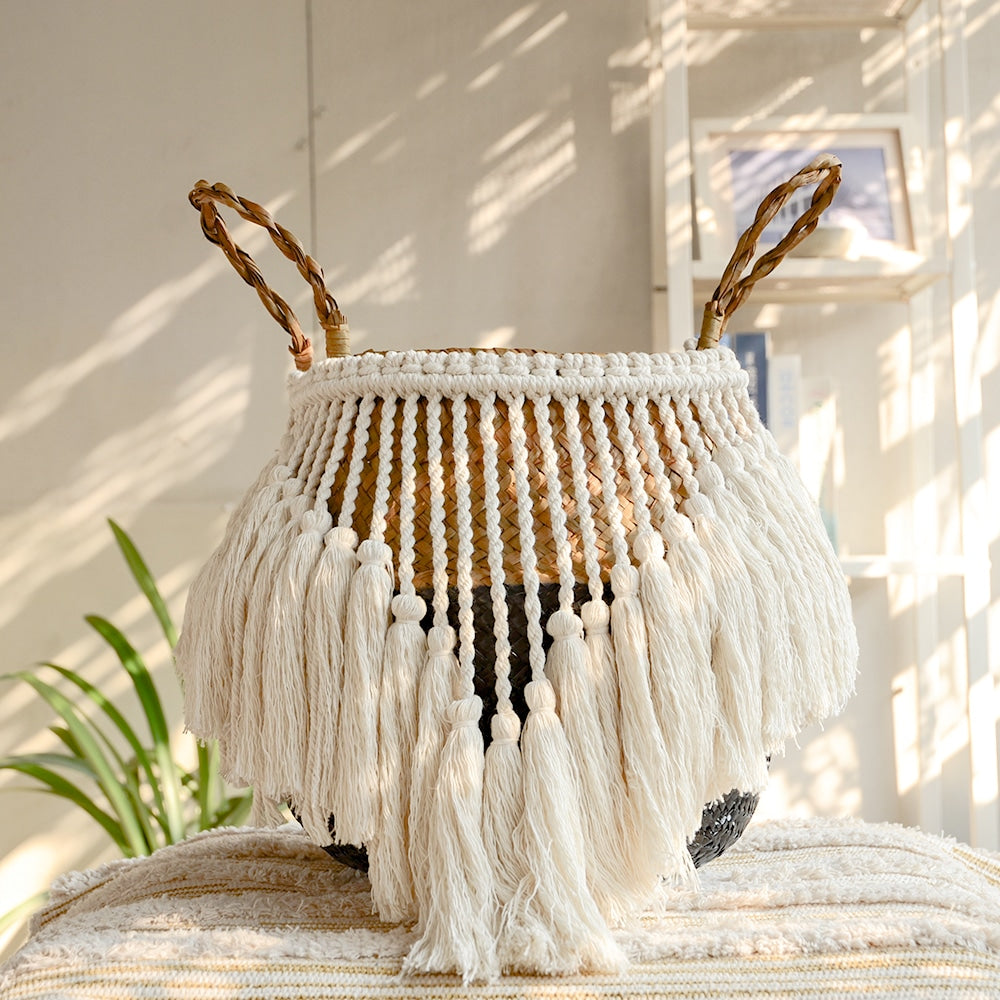 Black and beige wicker basket with a fringed border and white pompoms – shown in a room setting (2)