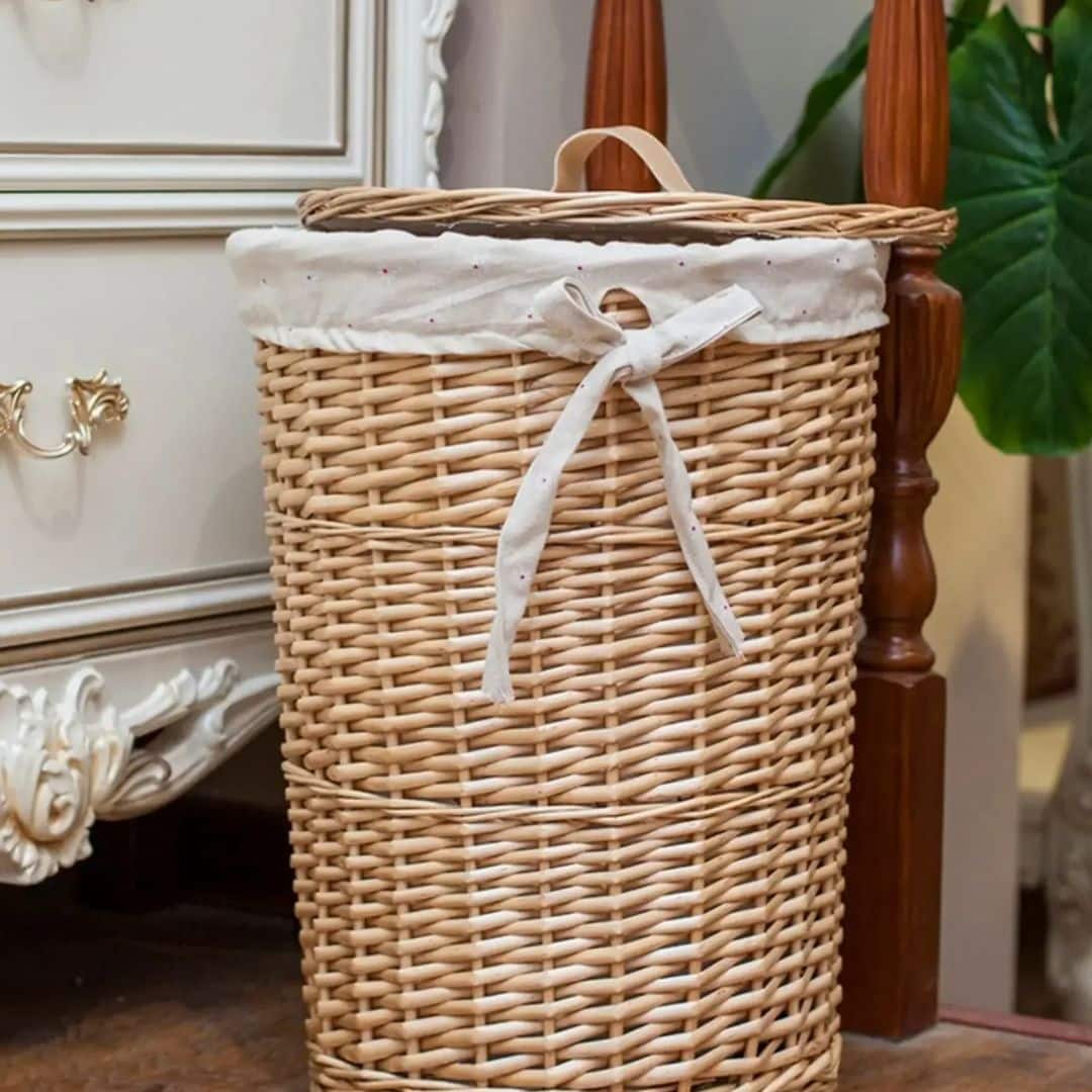 Round rattan laundry basket with a soft cotton lining – shown in a room setting