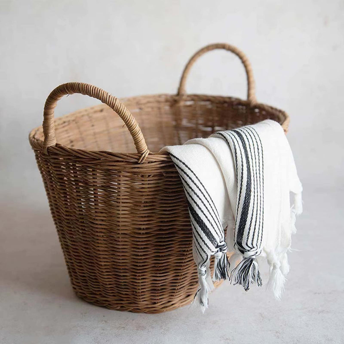 Sturdy vintage rattan laundry basket with a flared, ribbed silhouette – shown in a room setting