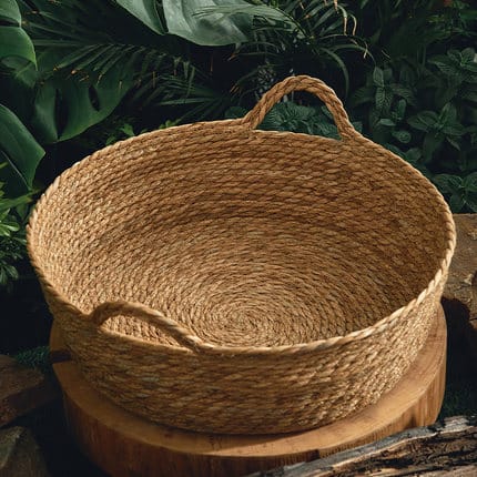 Round woven rattan dog bed with a tight braid – shown in a room setting