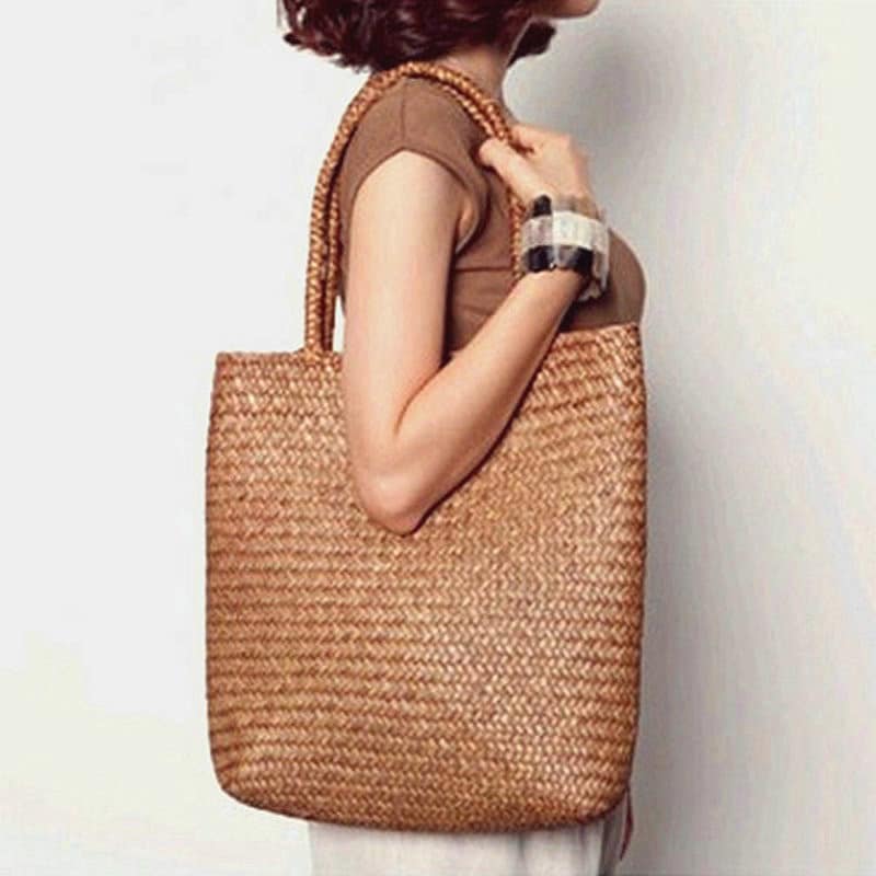 Handmade rattan shoulder basket bag with an adjustable strap – worn by a model