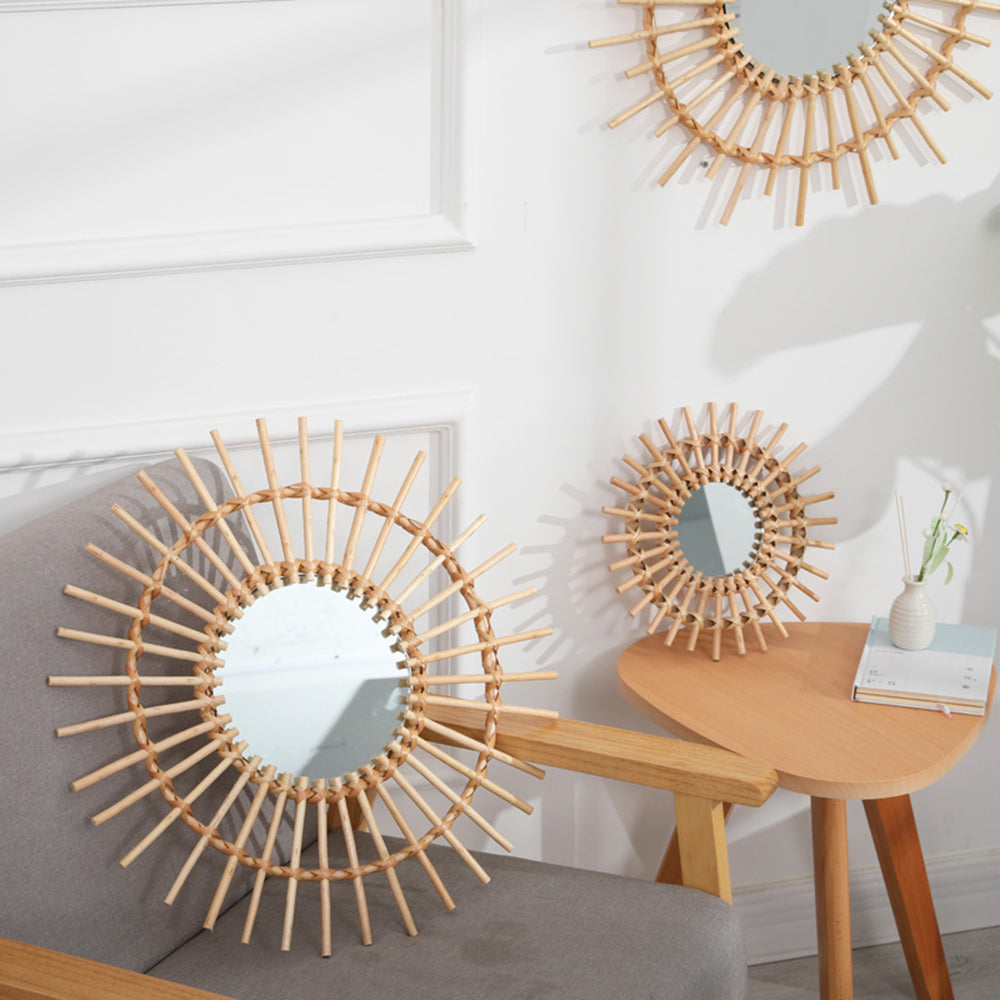 Small golden rattan sun mirror with hand-braided rays – shown in a room setting