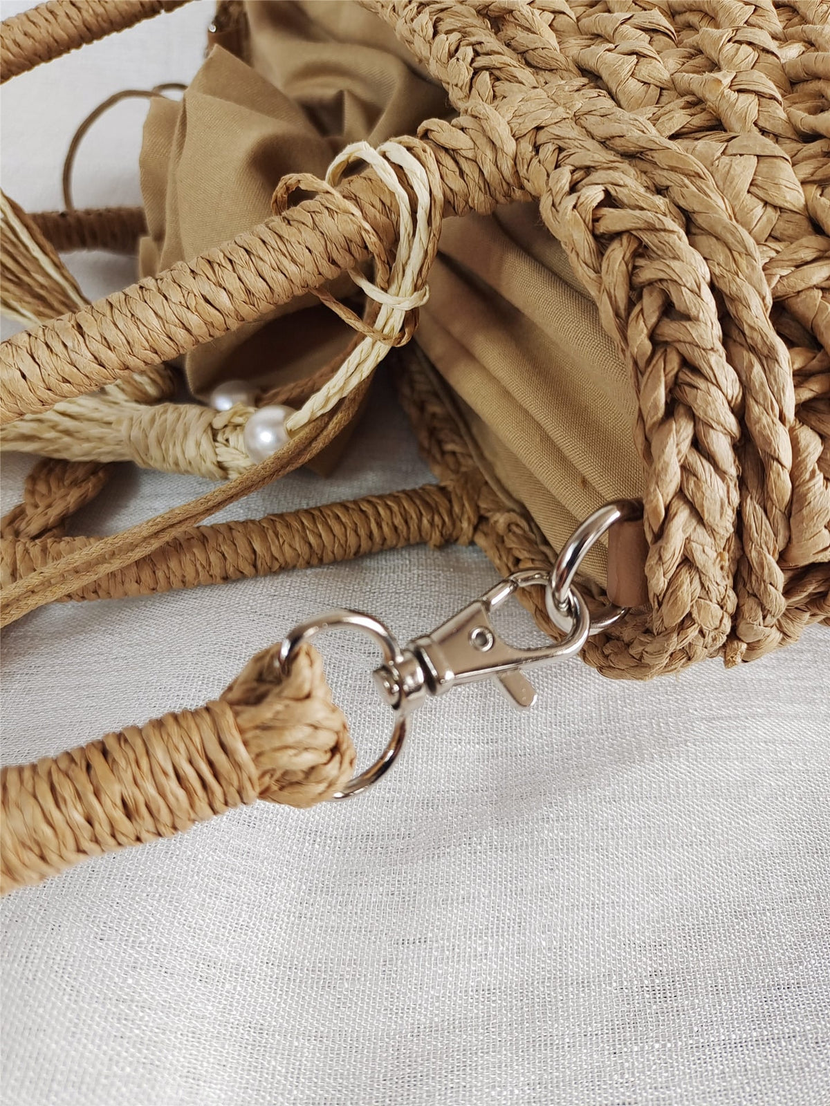 Small rattan handbag with rigid handles and a removable strap – close-up detail