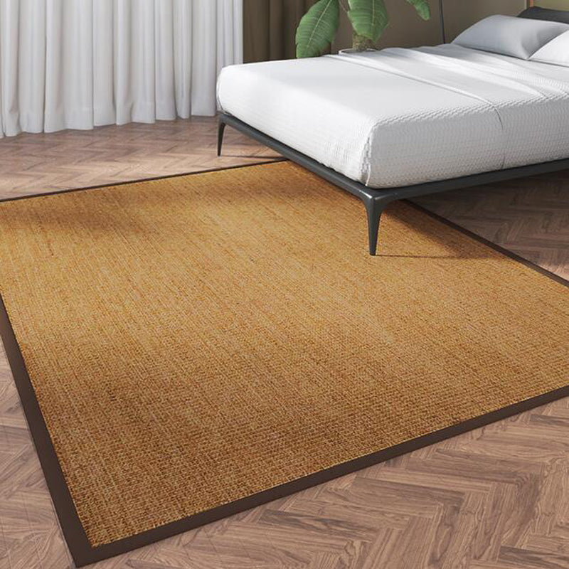 Small brown rectangular rattan rug with a braided border – shown in a room setting
