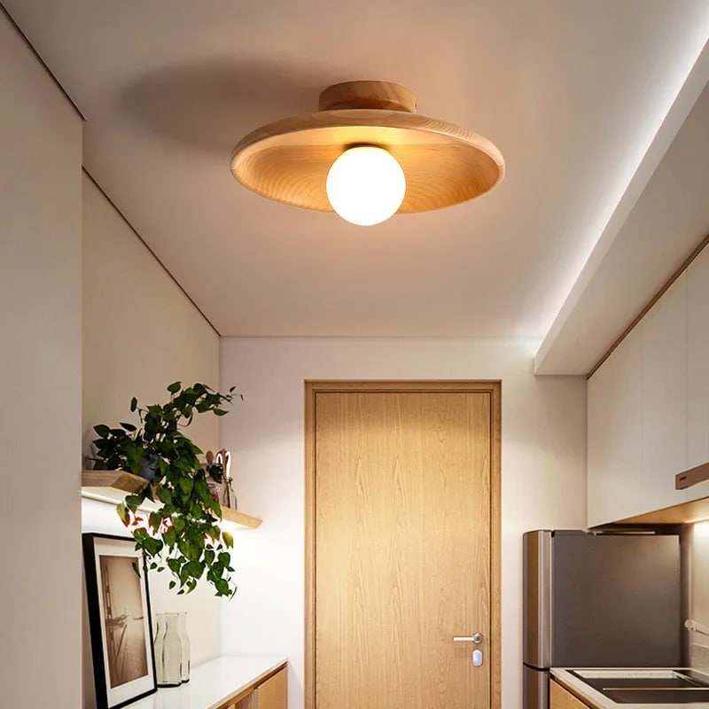 Nordic round light wood LED ceiling light with a matte finish – shown lit in a room setting