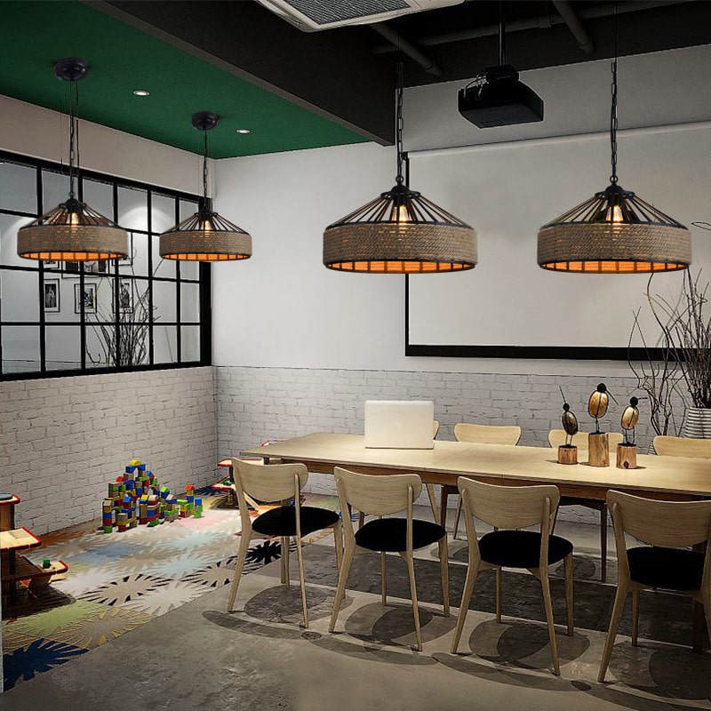Industrial black frame rattan pendant light hung on a chain – shown in a room setting