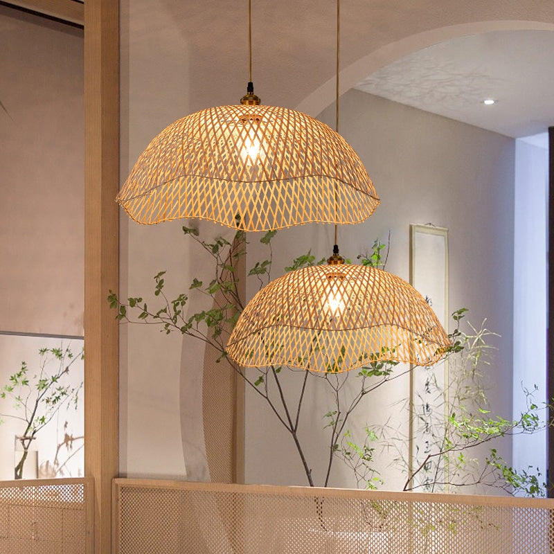 Modern geometric handwoven rattan, wicker and bamboo ceiling light – shown lit in a room setting
