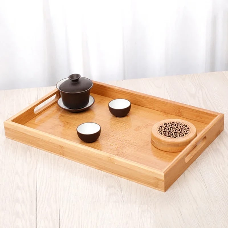 Rectangular bamboo tray with handles and a smooth golden surface