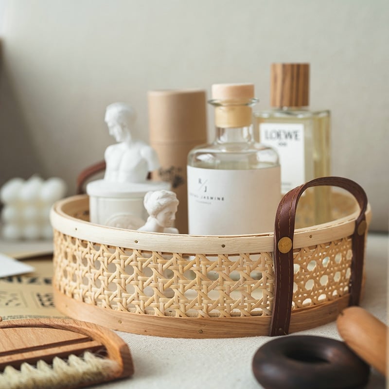Round white rattan tray with a sewn leather handle – shown in a room setting