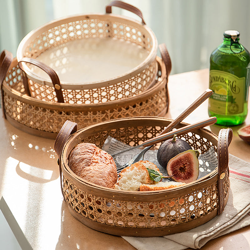 Round brown rattan tray with hand-sewn leather handles – shown in a room setting