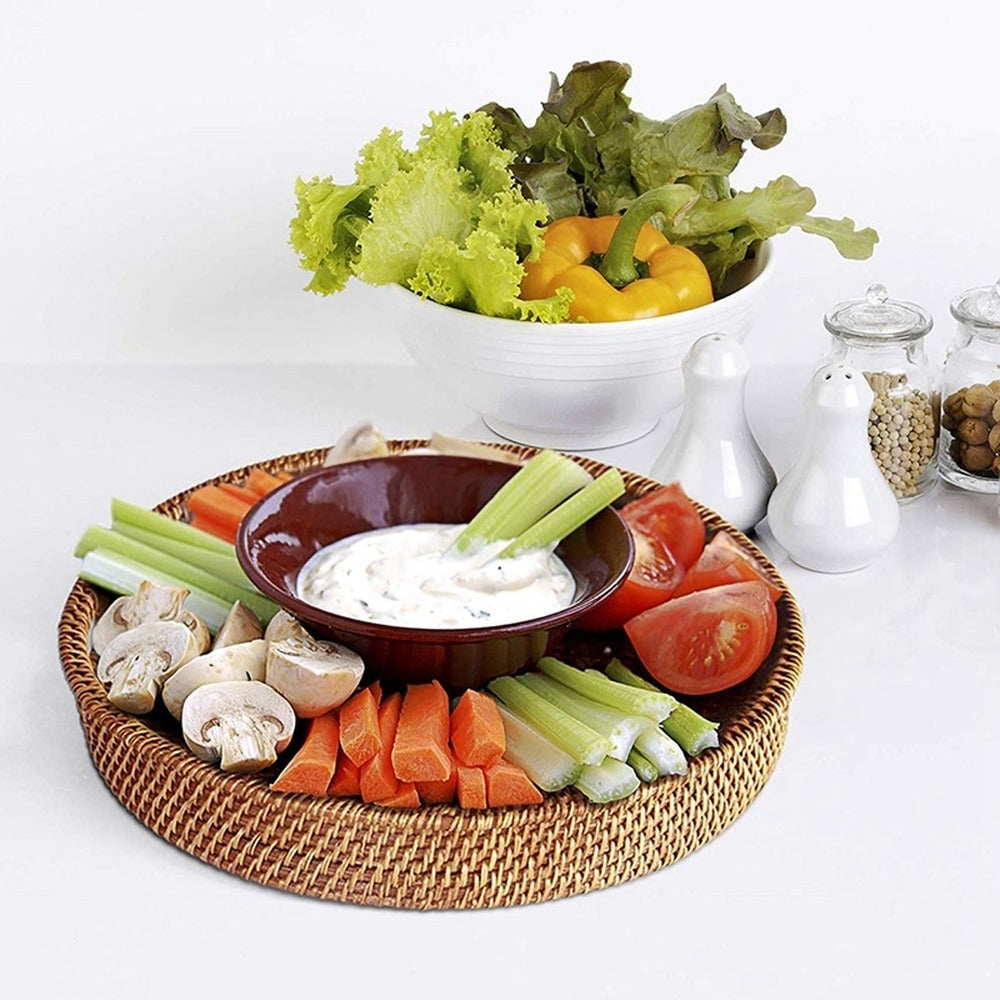 Round woven rattan serving tray with side cutout handles – shown in a room setting