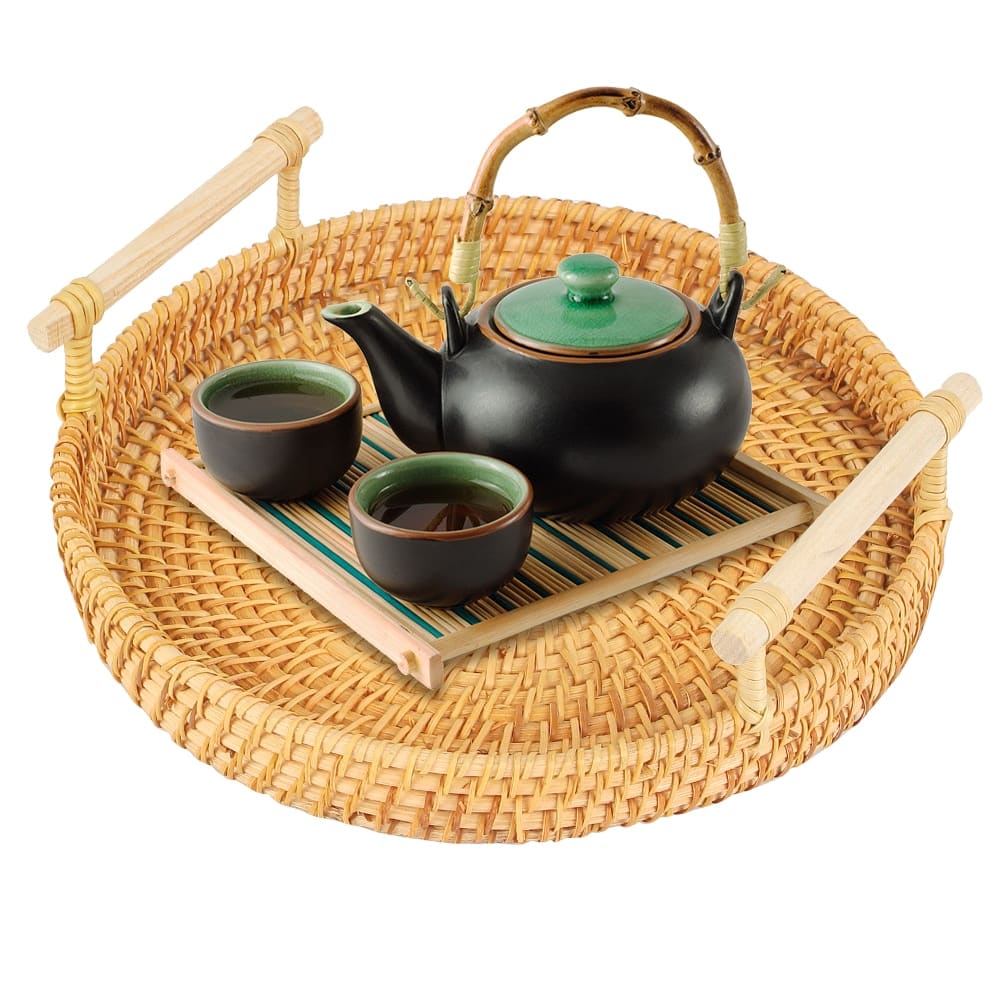 Round hand-braided rattan tray with a curved center handle – shown in a room setting