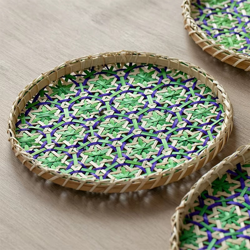 Round rattan tray with a beige, blue and green geometric pattern – close-up detail