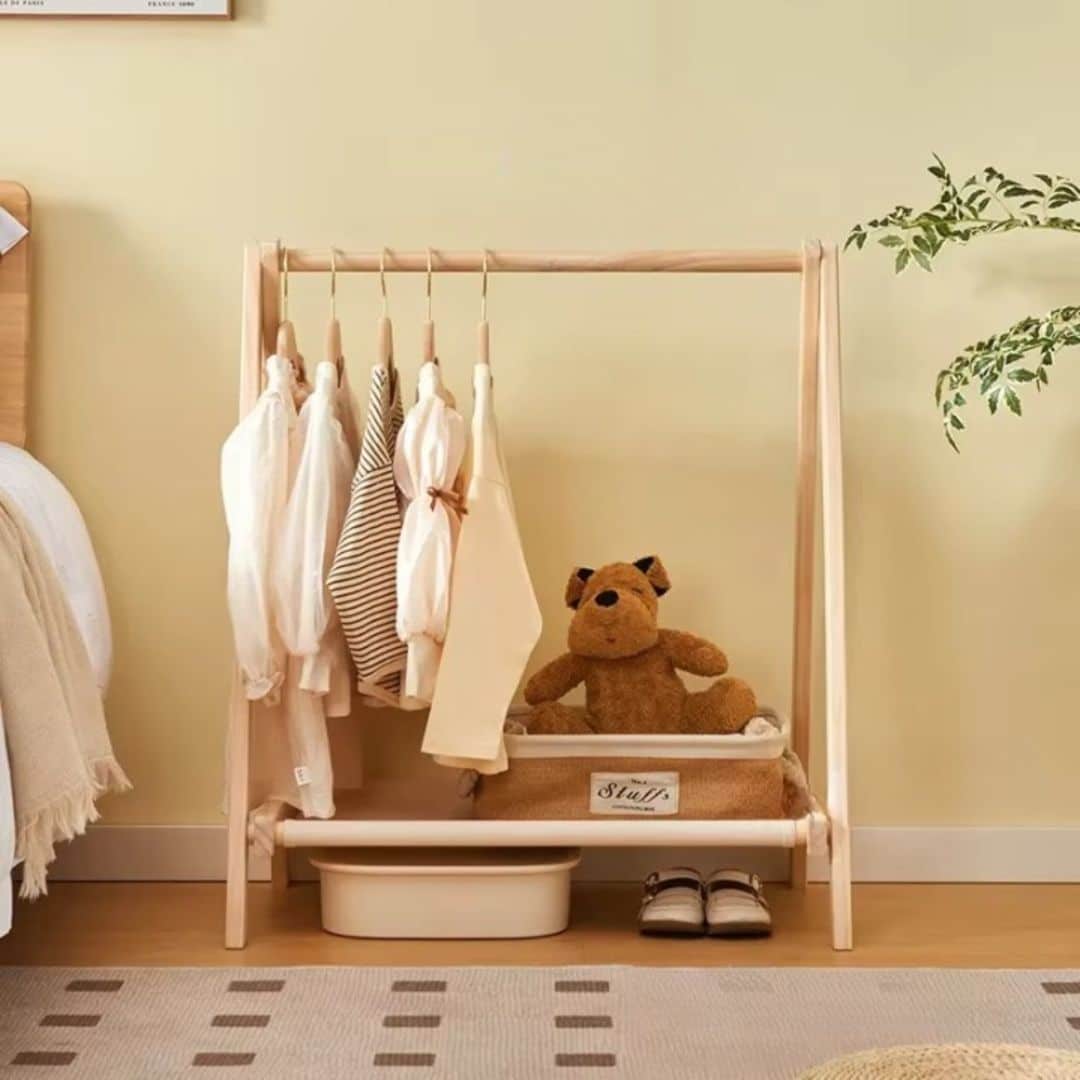 Modern folding wooden clothes rack with a cross frame – shown in a room setting