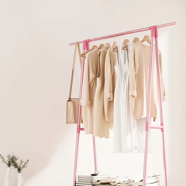Pink two-tier rolling clothing rack with wood-look uprights – shown in a room setting (2)