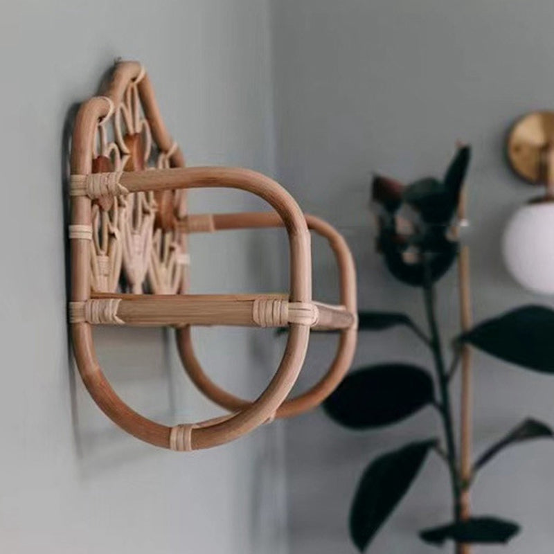 Natural rattan wall coat rack with a hanging rail and floral top shelf – shown in a room setting