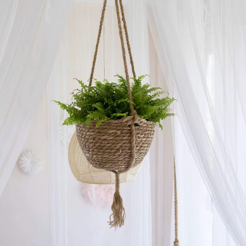 Boho hanging rattan planter with a rounded shape – shown in a room setting