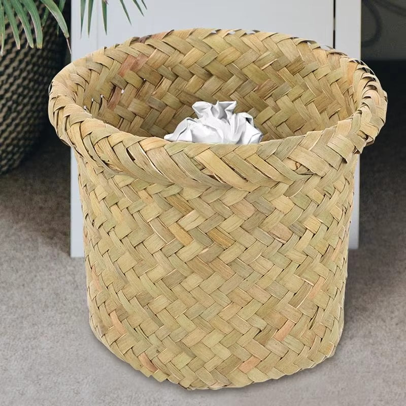 Compact round rattan wastebasket in a sand color – shown in a room setting (2)