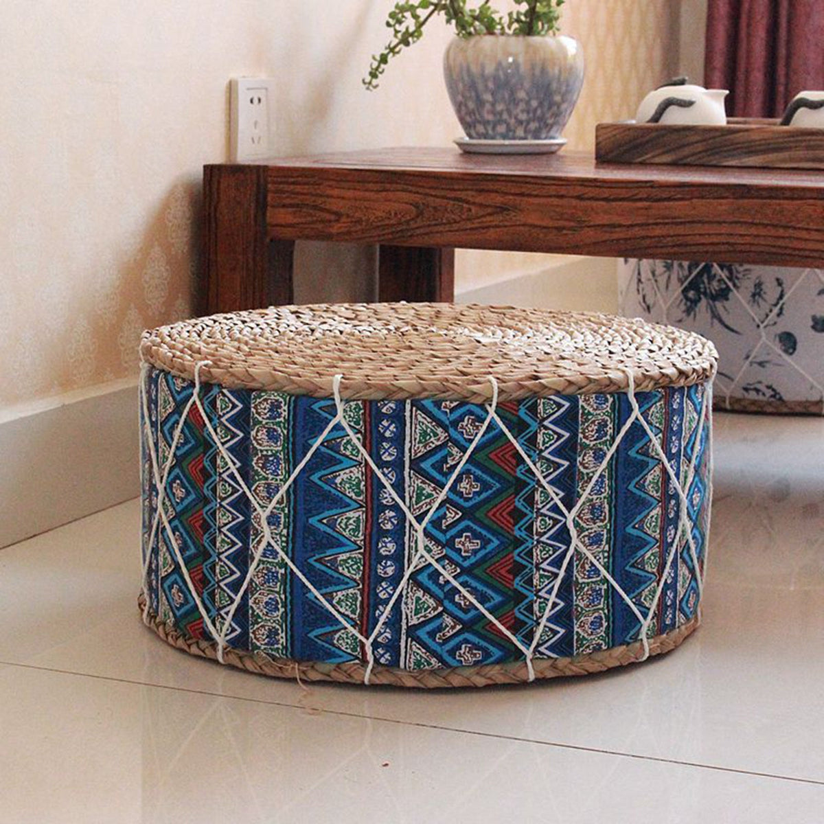 Round woven pouf with a blue-tone pattern – shown in a room setting