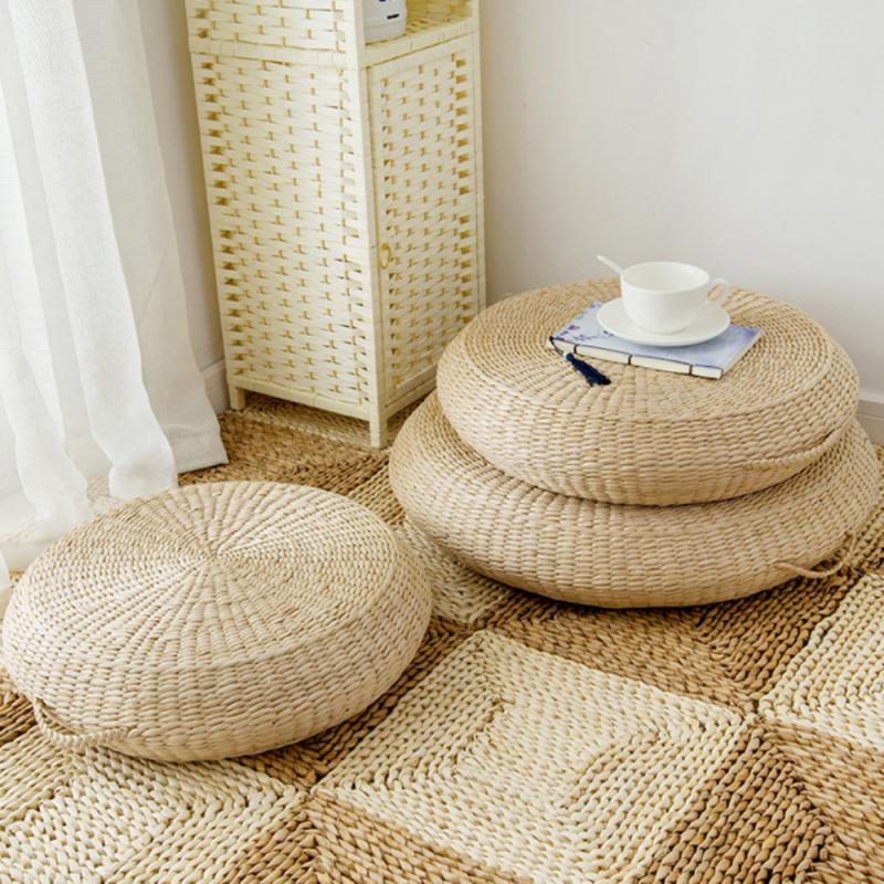 Light rattan pouf with a built-in handle – shown in a room setting (2)
