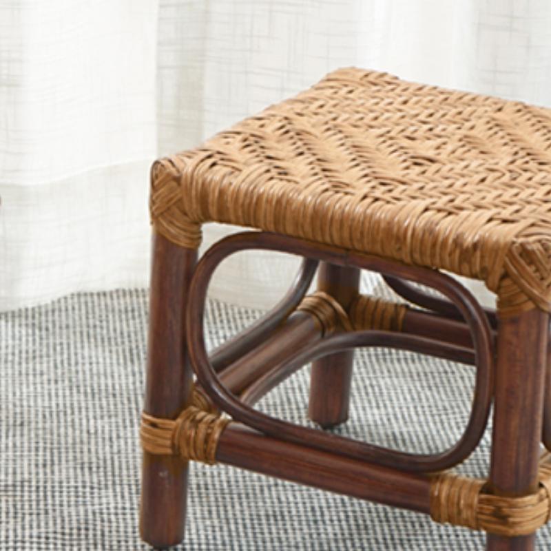 Dark brown wood footstool with a hand-braided rattan seat – close-up detail