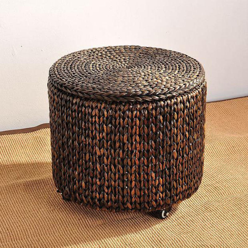 Brown hand-braided rattan footstool on casters with a removable lid – shown in a room setting