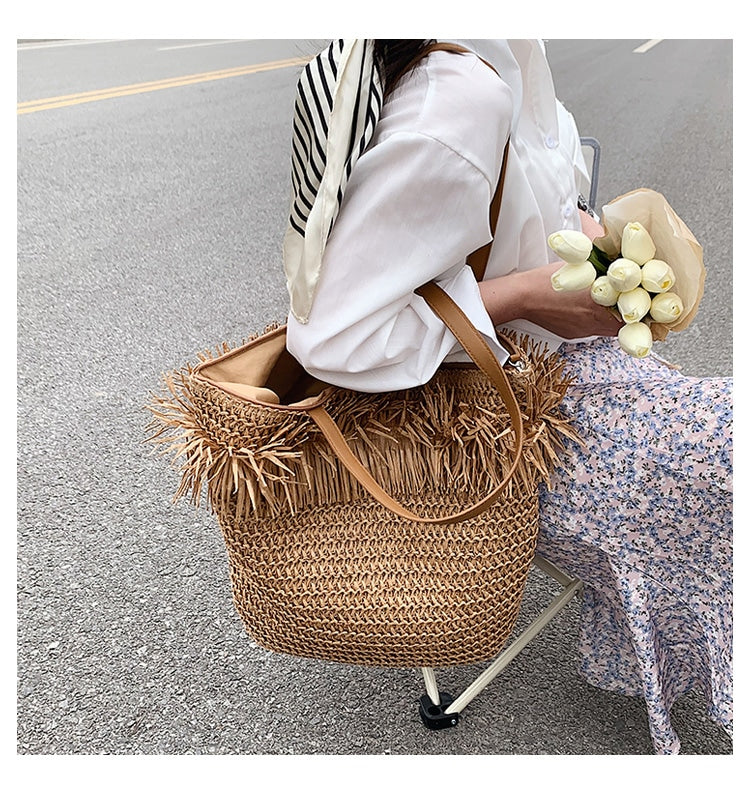 Large white straw crossbody bag with fringe – worn by a model