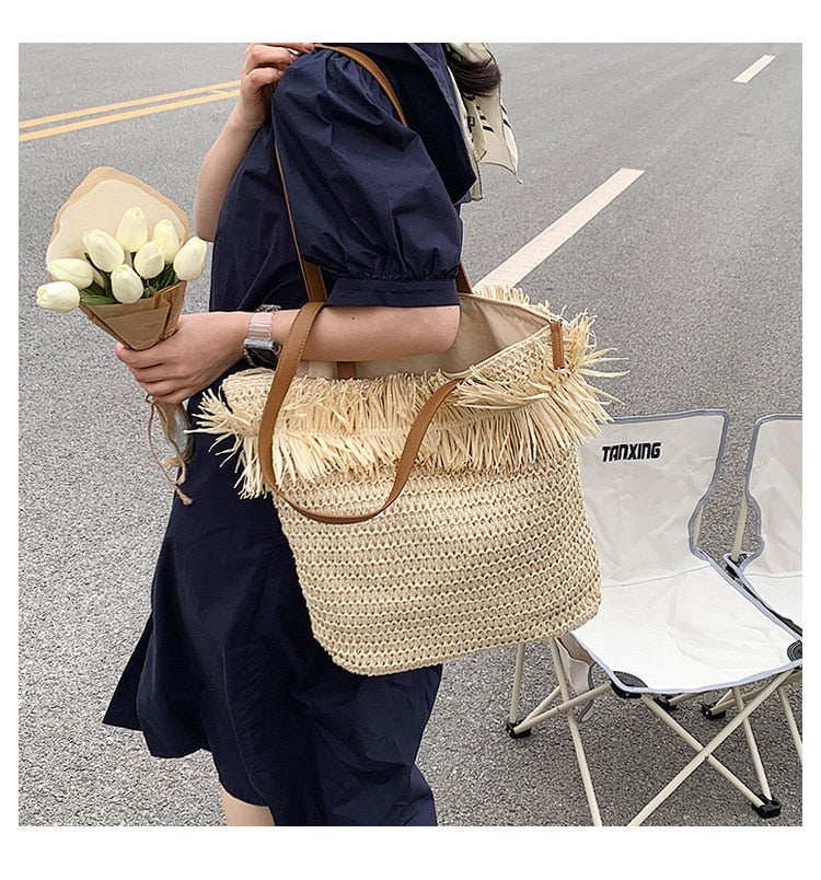 Large white straw crossbody bag with fringe trim – worn by a model (2)