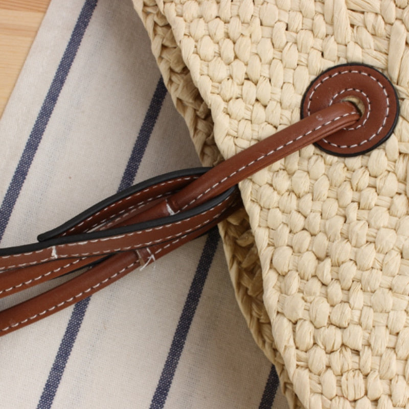 Handwoven straw handbag with two-tone brown handles – close-up detail