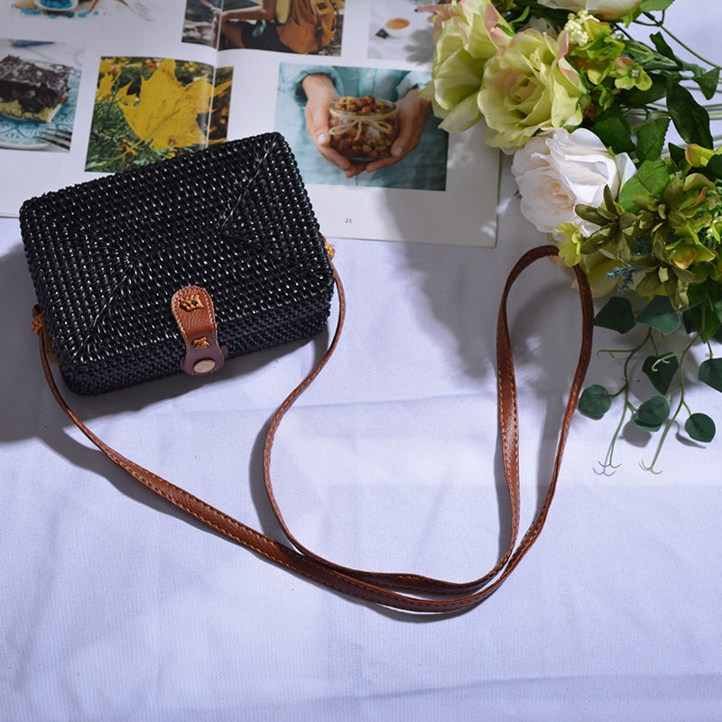 Square boho handwoven rattan handbag – black variant, shown in a room setting