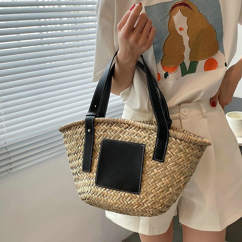 Black handwoven raffia summer bag – worn by a model