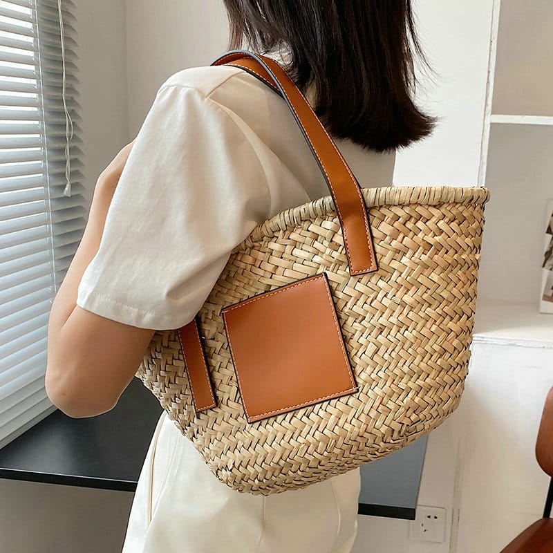 Black handwoven raffia summer bag – worn by a model