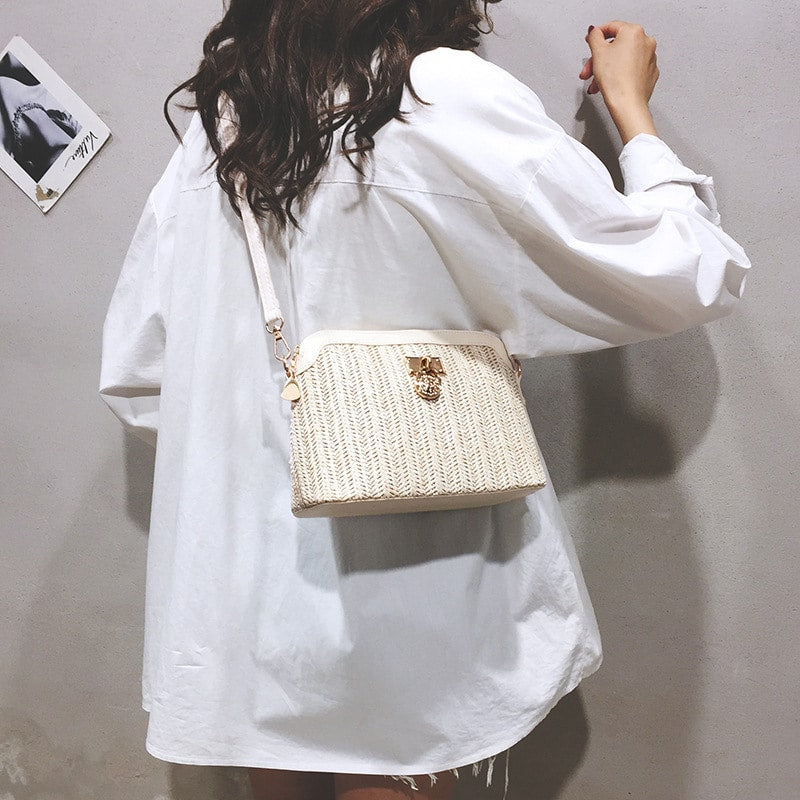 Beige rattan beach bag with gold chain handles – worn by a model (2)
