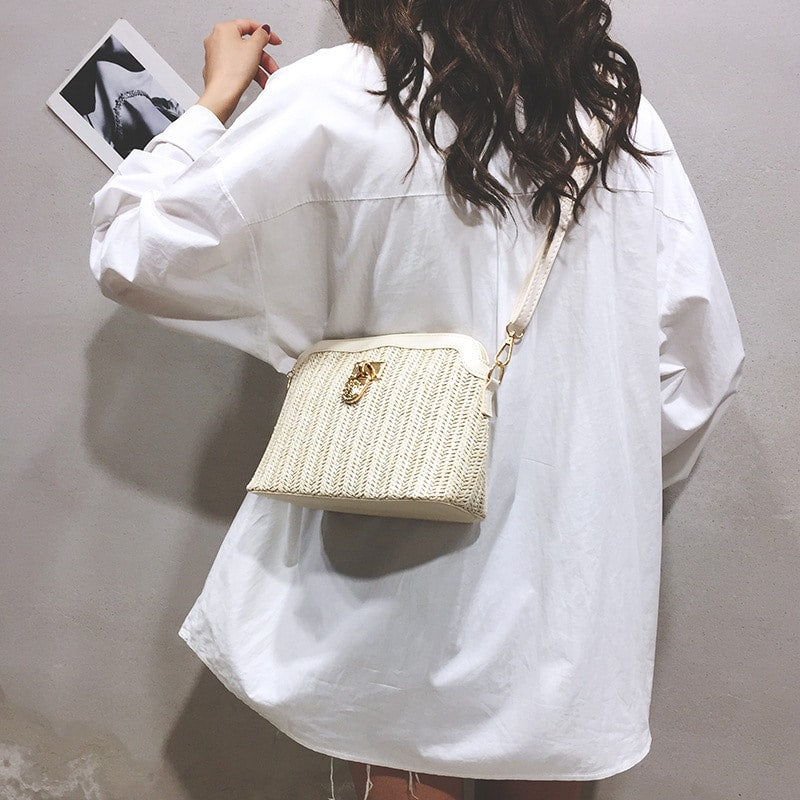 Beige rattan beach bag with gold chain handles – worn by a model (3)